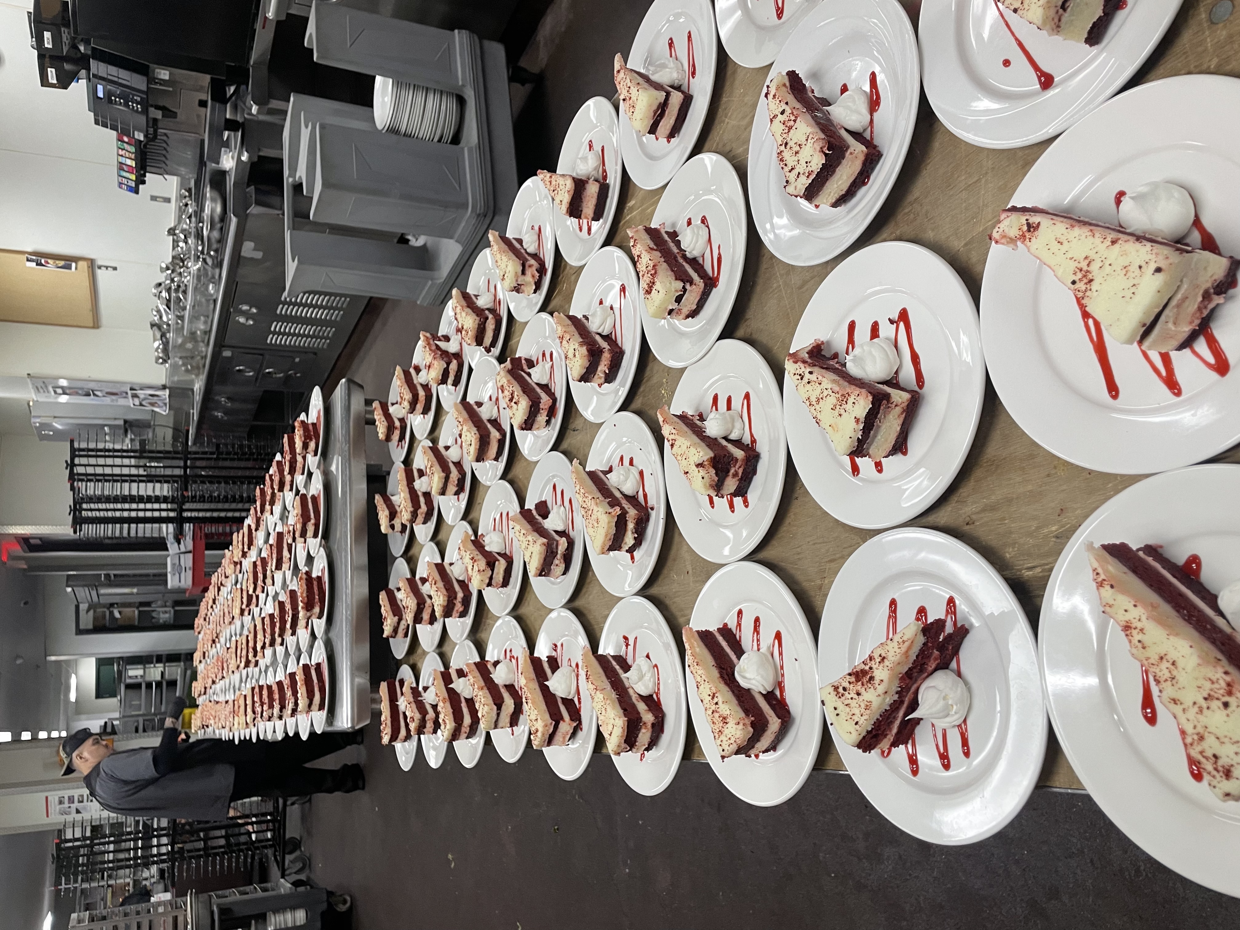 Rows of individually plated desserts prepared for a large event